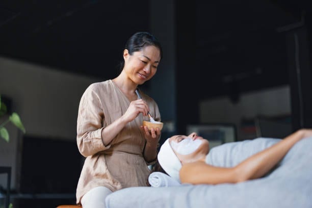 Therapist performing a relaxing facial in a calm treatment room Therapist performing a relaxing facial in a calm treatment room
