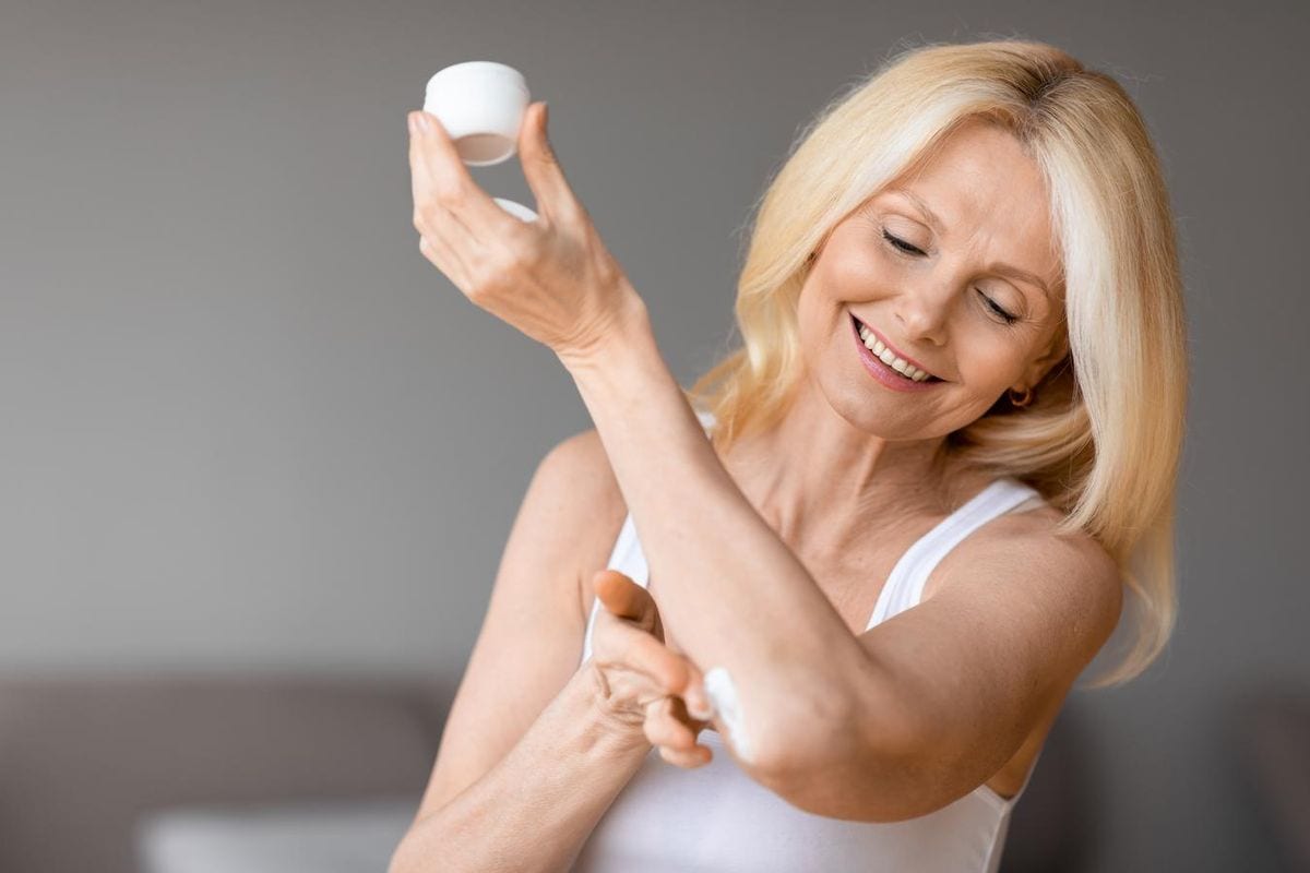 Woman applying brightening cream along her arm and elbow Woman applying brightening cream along her arm and elbow