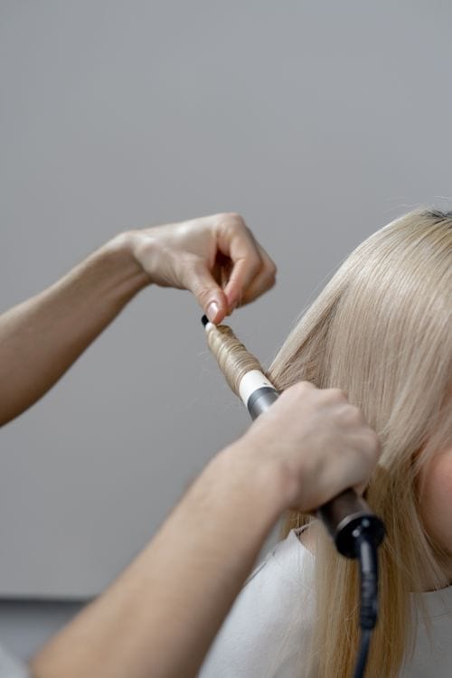 Professional styling long hair with a heated salon tool