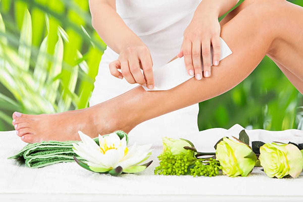 Wax strip being smoothed onto a client's leg Wax strip being smoothed onto a client's leg