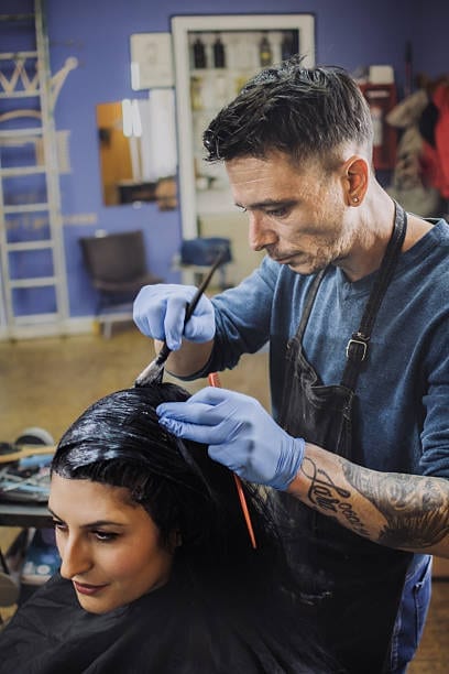 Barber applying hair colour to a male client