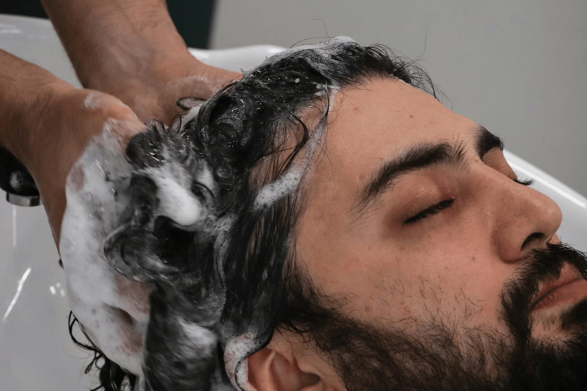 Man receiving a shampoo scalp massage at the salon basin